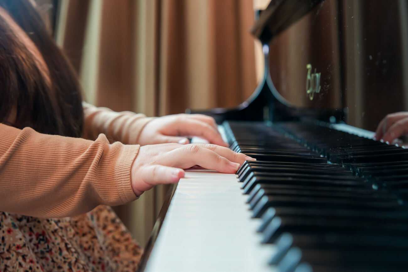 A student's hands resting on the piano keys mid-lesson